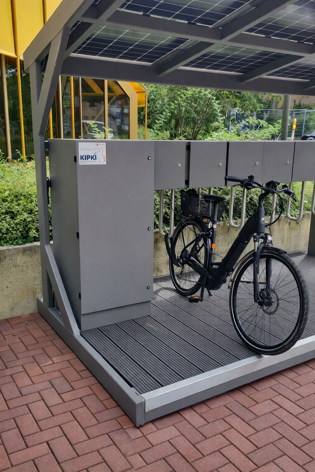 KIPKI Label auf dem Schaltkasten der autarken Ladestation von Fend Solar in Bad Dürkheim und abgestelltes Fahrrad