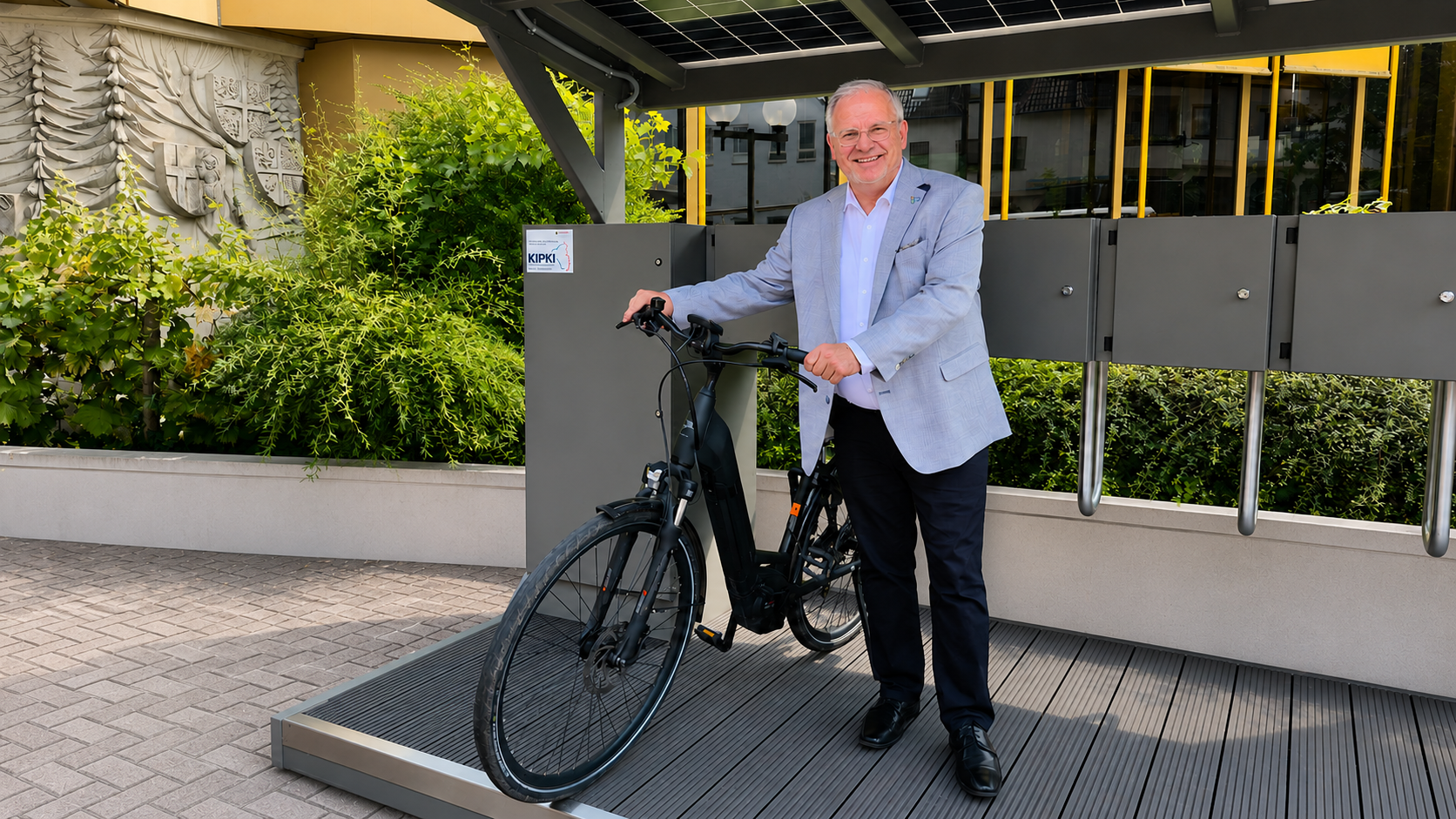 Landrat Hans-Ulrich Ihlenfeld an der neuen E-Bike-Ladestation mit Fahrrad in Bad Dürkheim