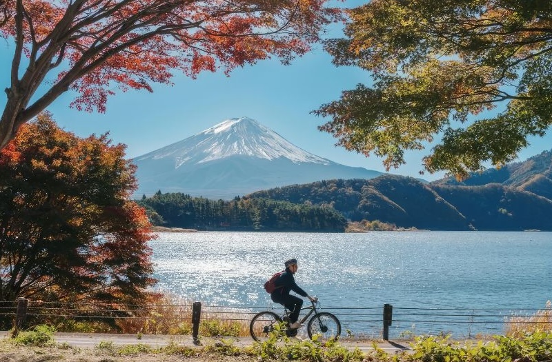 Landschaft mit See und Berg sonniges Wetter und Radfahrer