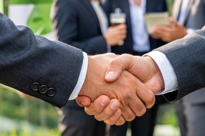 Händeschütteln und andere Partner im Hintergrund
